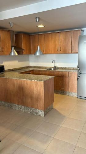 a kitchen with a counter and a refrigerator at Acogedor apartamento en la playa con WIFI y AACC in Moncófar