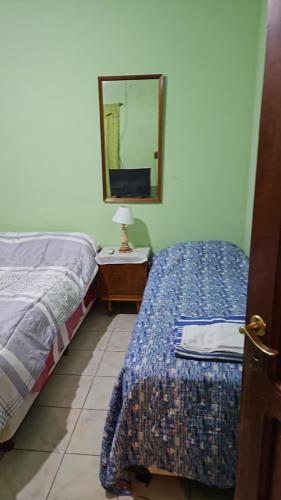 um quarto com 2 camas e um espelho na parede em Luna de Belén em Belén