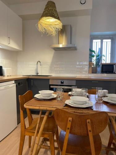 - une cuisine avec une table en bois, des chaises et un évier dans l'établissement Les appartements d'Albertine - Pauline, à Bourges