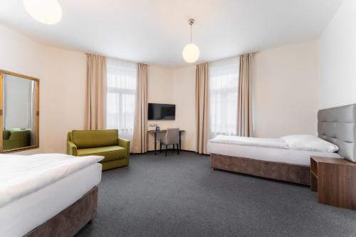 a hotel room with two beds and a chair at EA Hotel Victoria in Prague