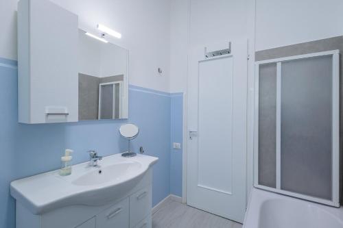 a white bathroom with a sink and a shower at La Casa di Ciussi in Bergamo