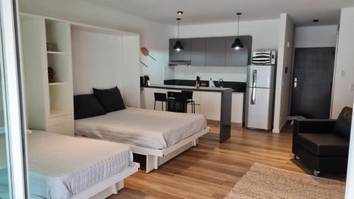 a living room with two beds and a kitchen at Apart Las Heras in Florida