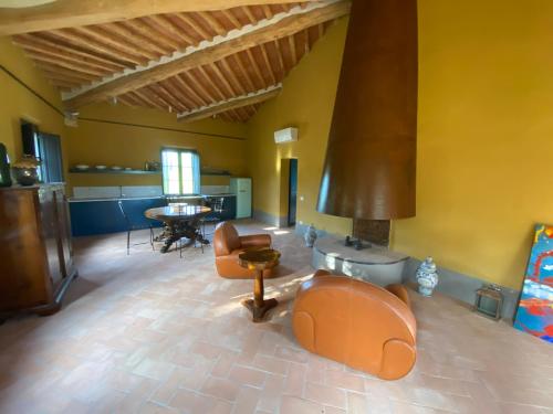 salon z pomarańczowymi meblami i stołem w obiekcie Villa Cosmiana: the gate house apartment w mieście Peccioli