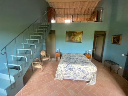sypialnia z łóżkiem i spiralnymi schodami w obiekcie Villa Cosmiana: the gate house apartment w mieście Peccioli