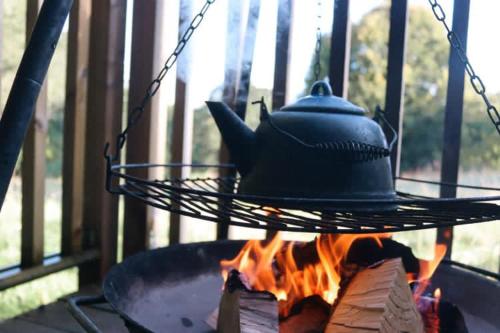 a kettle on top of a grill over a fire at Eisa Yurt in York