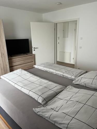 a room with two beds and a flat screen tv at Ferienwohnung am Yachthafen in Kressbronn am Bodensee