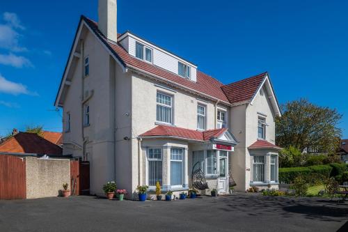 a large white house with a red roof at Rosaire Guest House in Llandudno