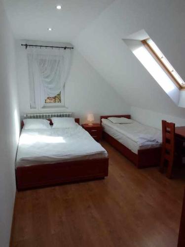 a bedroom with two beds and a window at Nad Strumykiem in Koszele