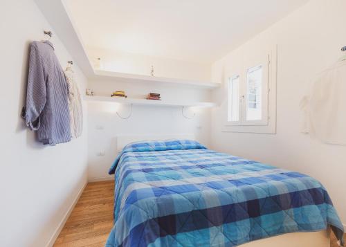 a bedroom with a bed with a blue comforter at Blue Domus in Cagliari