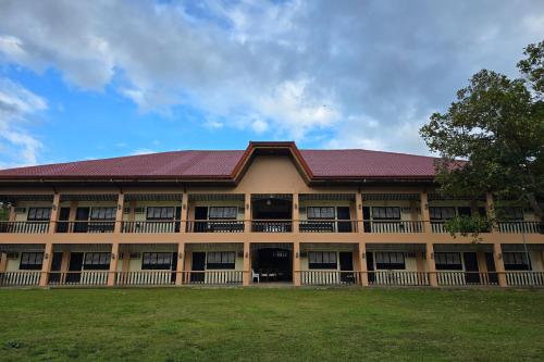 a building with a red roof and a grass field at Grand Villa Laguna in Manila
