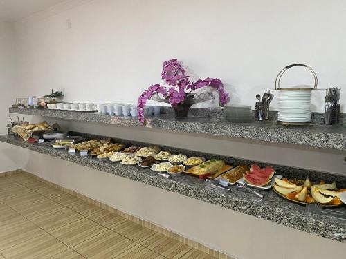 a row of shelves filled with different types of food at Hotel Itamaraty in Várzea Grande