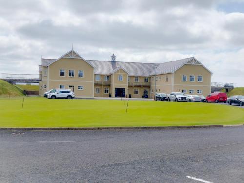 a large building with cars parked in front of it at Blue Door Apartment Main St, Carrigart, F92HC04 in Carrigart