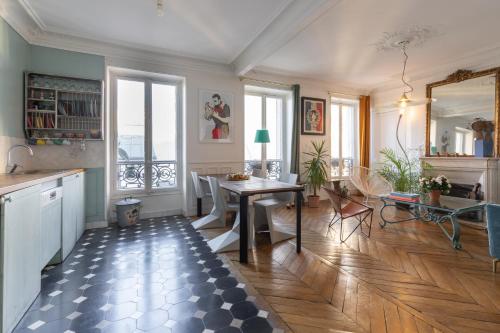 a kitchen with a table and a dining room at Marais Magique: Exclusive Apartment in Paris in Paris