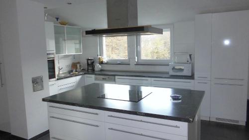a kitchen with white cabinets and a black counter top at Stuifenblick in Waldstetten