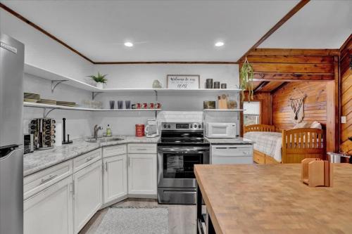 a kitchen with white cabinets and a stove top oven at Cabin in Long Pond Gameroom Pool Table in Long Pond