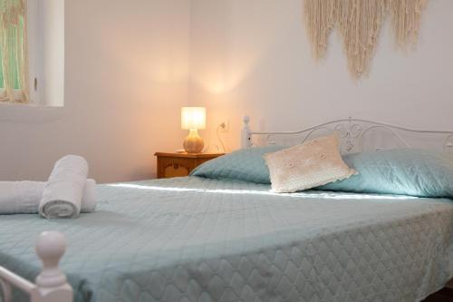 a bedroom with a white bed with blue pillows at Melitini's House in Alinda
