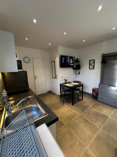 - une cuisine avec un évier et une table dans l'établissement Maisonnette 2 pers tout confort près de Paris, à Bobigny