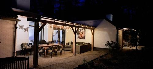 a patio with a table and chairs in a house at night at Knabbel en Babbel in Lochem