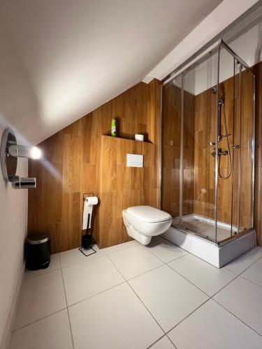 a bathroom with a toilet and a glass shower at Centrum Dialogu Kultur in Węgrów