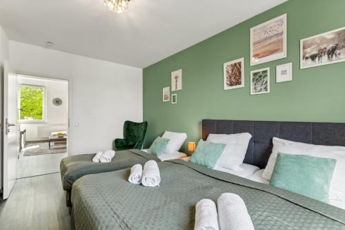 two beds in a bedroom with green walls at Elegant & Bright ~ Near Schalke 04 ~ Office ~ Free Parking! in Gelsenkirchen
