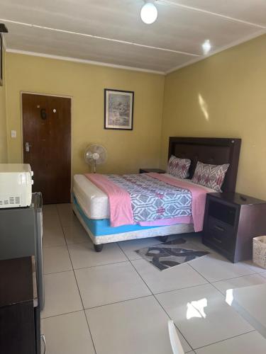 a bedroom with a bed and a tv in it at Salvador Building in Vereeniging
