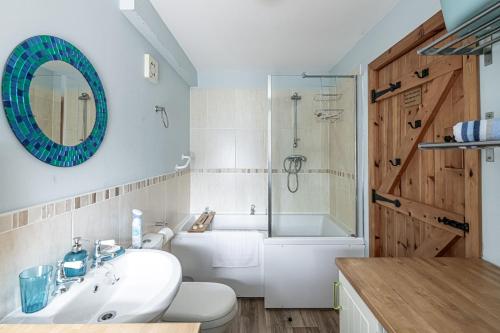a bathroom with a sink and a toilet and a tub at Penrhyn Cottage in Cemaes Bay