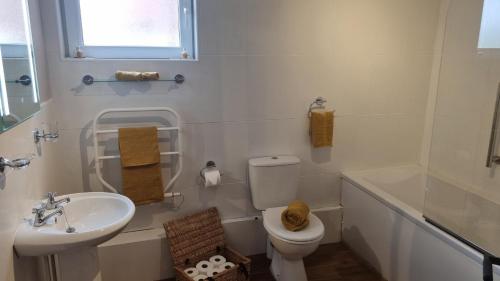 ein weißes Bad mit einem Waschbecken und einem WC in der Unterkunft Wheelwright's Cottage in Yeaveley