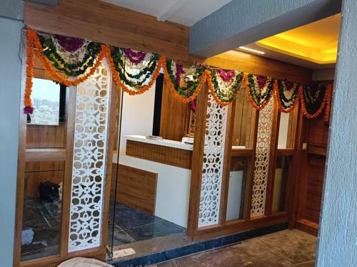Zimmer mit Holzwänden und Fenstern mit Vorhängen in der Unterkunft Hotel RK ICON in Ahmedabad