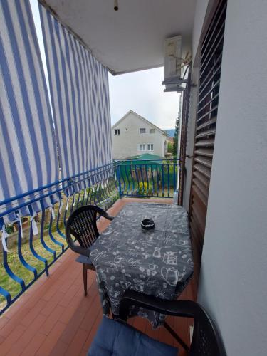 a balcony with a table and chairs on a balcony at Barcelona Apartments in Tivat