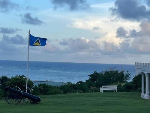 a blue flag on top of a field with a bench at Castles Apartments in Castries