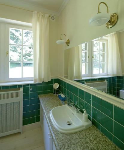 a bathroom with a sink and a mirror at Villa Titina in Miedzygorze