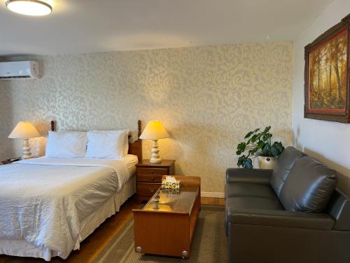 Habitación de hotel con cama y sofá en Lee's Ocean Peek B & B, en Stratford