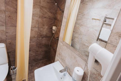 a bathroom with a shower and a toilet and a sink at Viiking Spa Hotel in Pärnu