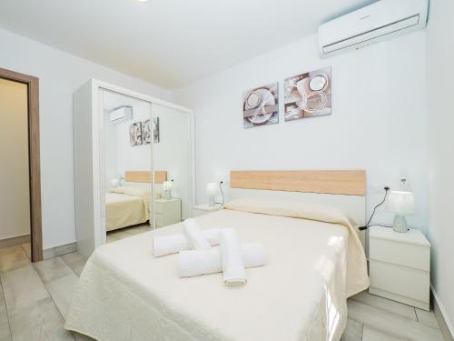 um quarto branco com uma cama com toalhas em Cubo's Casa Rural Maylu em Cártama