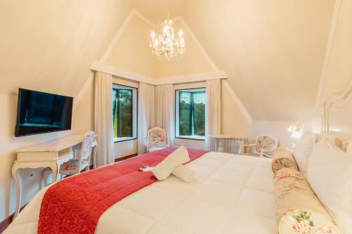 een grote witte slaapkamer met een groot bed en een bureau bij Villa D´Biagy Premium in Campos do Jordão