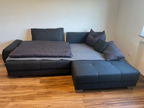 a bed with pillows on top of a blue couch at Ferienglück am Spielplatz in Günzburg