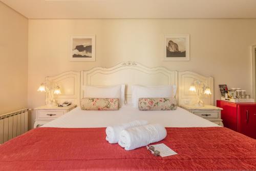 a bedroom with a large bed with two towels on it at Pousada D'Biagy Premium in Campos do Jordão