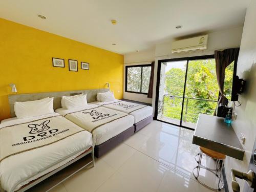 twee bedden in een kamer met gele muren bij Ideo Phuket Hotel - SHA Extra Plus in Nai Yang Beach