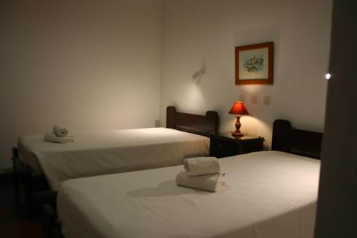 Cette chambre comprend deux lits et une lampe sur une table. dans l'établissement Aldeia Da Falesia, à Albufeira