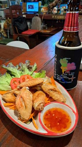 a plate of food with a bottle of wine and salad at Apache Bar Haad yao in Haad Yao