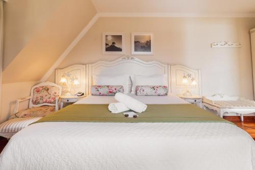 a bedroom with a large white bed with two pillows at Pousada D'Biagy Premium in Campos do Jordão