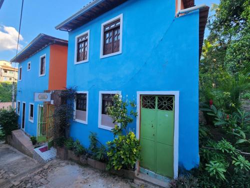 a blue house with a green door at Pousada Velho Garimpo in Lençóis