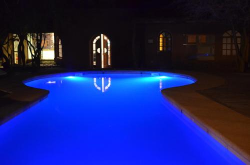 a pool with blue lights in a yard at night at Hotel La Aldea in San Pedro de Atacama