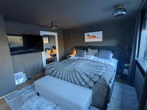 1 dormitorio con cama y banco. en Spacious & luxurious family home w hot & cold tub & sauna, en Reikiavik
