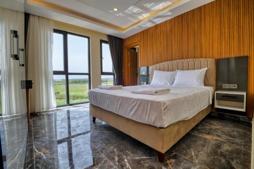 a bedroom with a large bed and a large window at Evin Park Suit Lara in Aksu