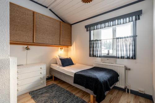 Habitación pequeña con cama y ventana en Lövåsgårdens Fjällhotell en Lövåsen