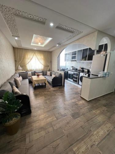 a living room with a couch and a kitchen at Appartement Dar Bouazza Tamaris Casablanca Airport AquaParc Fibre Orange Wifi Parking Security in Dar Bouazza