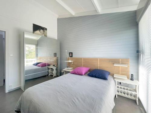 - une chambre dotée d'un grand lit avec des oreillers violets et bleus dans l'établissement Villa vue direct océan 21 couchages, à Hourtin