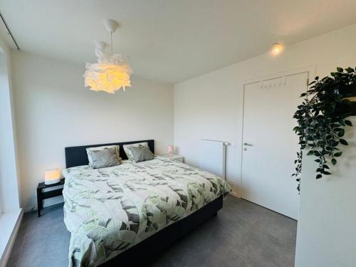 1 dormitorio con 1 cama y una maceta en Jolie appartement haut standing Liège Guillemins en Lieja