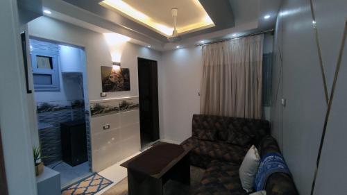 Una sala de estar con un sofá y un televisor. en فندق أجياد Agyad Hotel, en Asiut